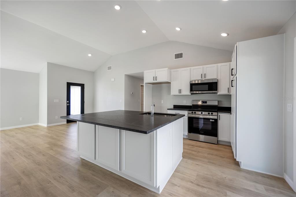 3294 West Price Boulevard North Port, FL 34286 - Photo 8 of 47 a kitchen with granite countertop a sink stove and refrigerator