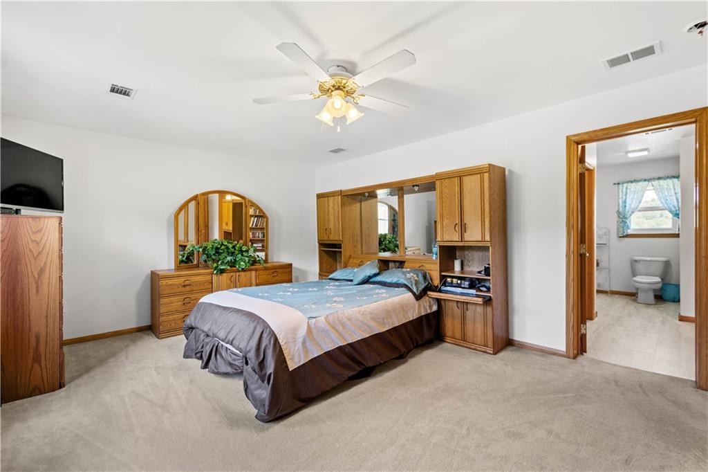 119 Cooper Road Slippery Rock, PA 16057 - Photo 18 of 25 a spacious bedroom with a bed a window and a chandelier