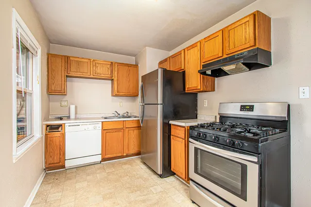 a kitchen with stainless steel appliances granite countertop a stove and a refrigerator