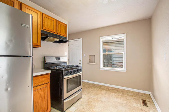 a kitchen with stainless steel appliances granite countertop a stove and a refrigerator