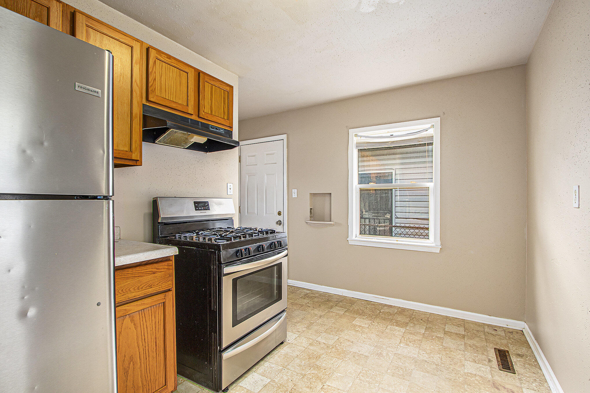 1350 Morton Street Gary, IN 46404 - Photo 8 of 17 a kitchen with stainless steel appliances granite countertop a stove and a refrigerator
