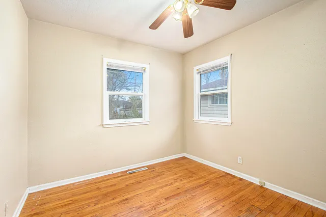 a view of empty room with wooden floor