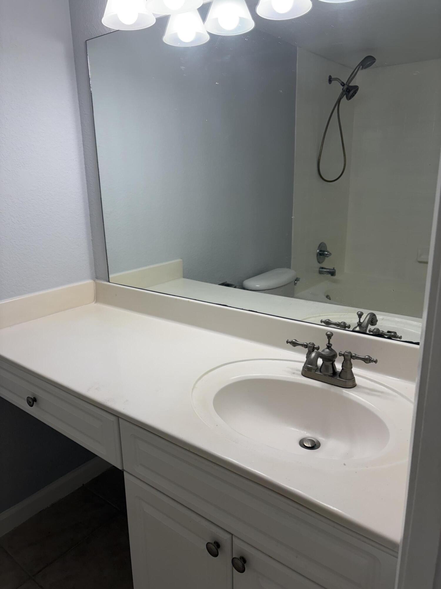 8165 Severn Drive, Unit D Boca Raton, FL 33433 - Photo 13 of 14 a bathroom with a sink and a mirror