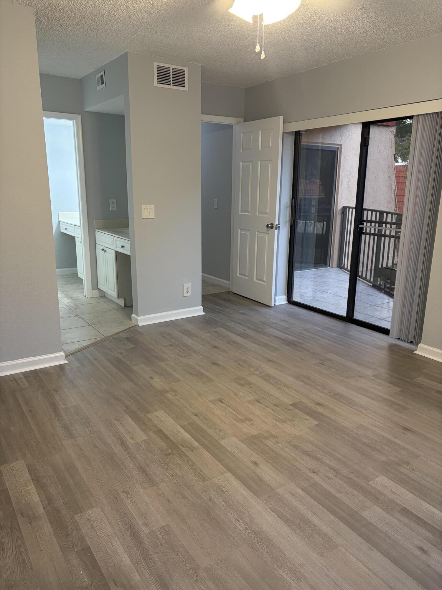 8165 Severn Drive, Unit D Boca Raton, FL 33433 - Photo 10 of 14 a view of an empty room with wooden floor and a window