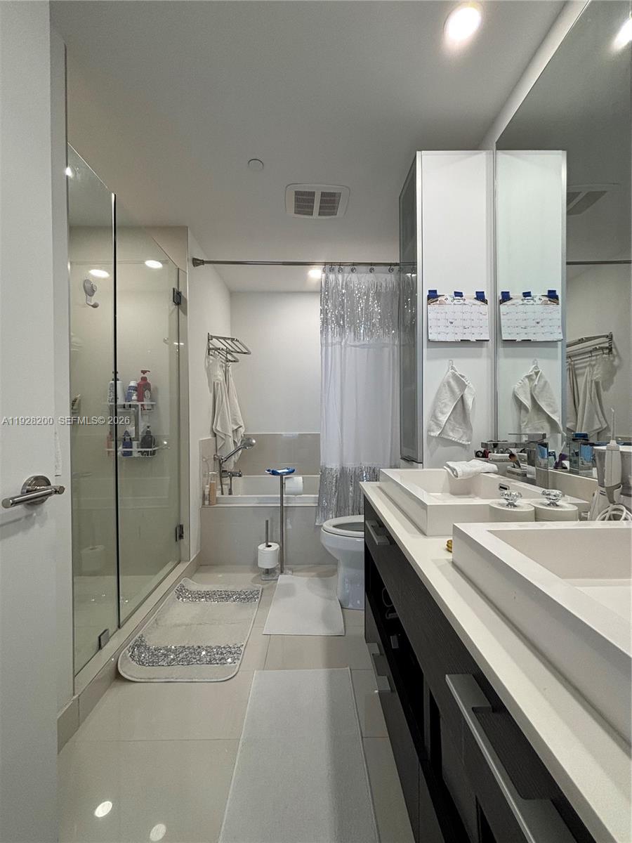 45 Southwest 9th Street, Unit 2303 Miami, FL 33130 - Photo 8 of 33 a spacious bathroom with a granite countertop sink mirror and bathtub