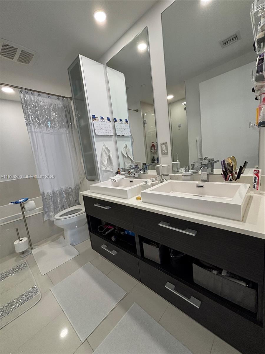 45 Southwest 9th Street, Unit 2303 Miami, FL 33130 - Photo 9 of 33 a bathroom with a double vanity sink and a mirror