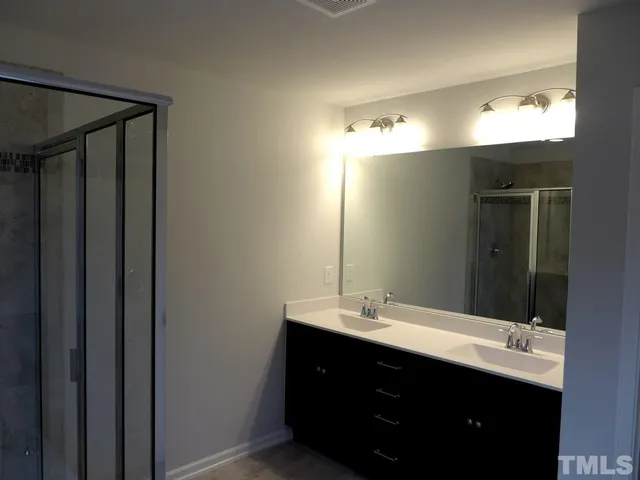 a bathroom with a double vanity sink and mirror