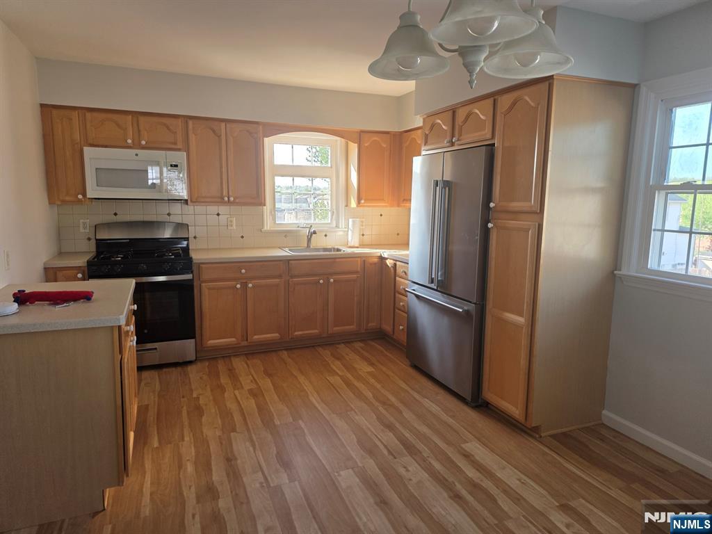 633 10th Street, Unit 2 Lyndhurst, NJ 07071 - Photo 3 of 11 a kitchen with stainless steel appliances granite countertop a refrigerator a stove a sink and dishwasher with wooden floor