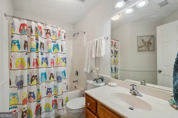 a bathroom with a sink a toilet and a shower curtain