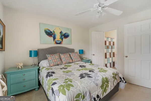 a bedroom with a bed and painting on the wall