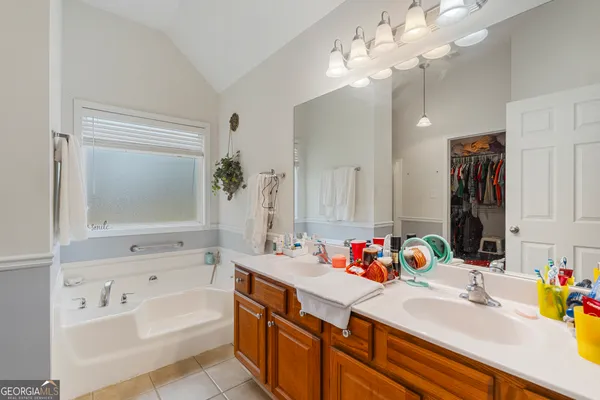 a bathroom with a tub a sink and a mirror