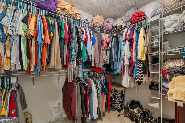 a view of walk in closet with clothes