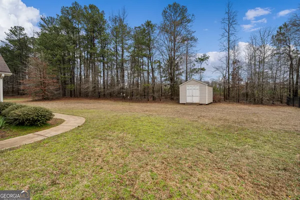 a view of a field with trees in the background