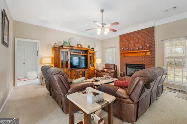 a living room with furniture a fireplace and a large window