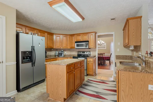 a kitchen with stainless steel appliances granite countertop a refrigerator stove and sink