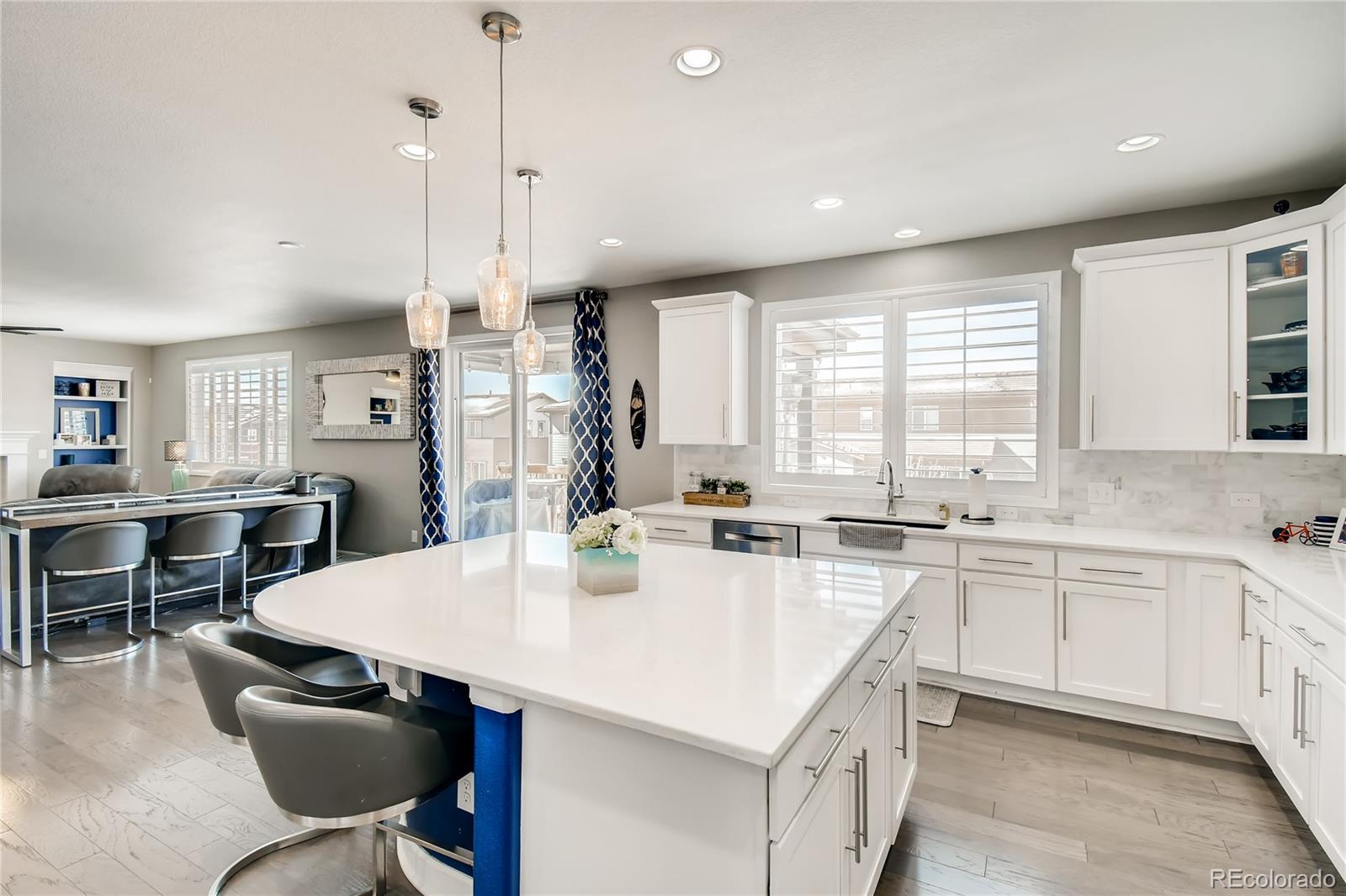 14402 Double Dutch Circle Parker, CO 80134 - Photo 7 of 31 a kitchen with stainless steel appliances granite countertop a sink a stove a refrigerator a dining table and chairs