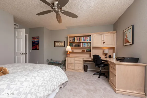 a bedroom that has a bed and a desk in it