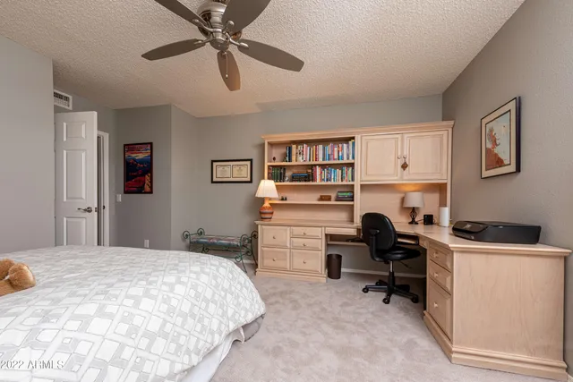 a bedroom that has a bed and a desk in it