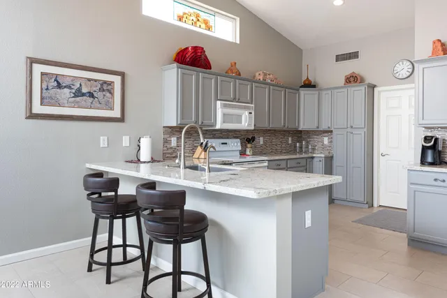 a kitchen with stainless steel appliances granite countertop a sink and a refrigerator