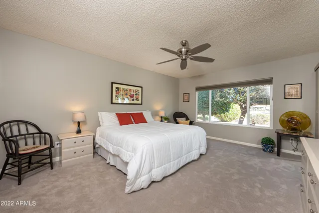 a bedroom with a bed a dresser and a window