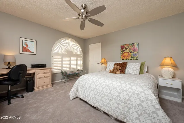 a spacious bedroom with a large bed and a chandelier