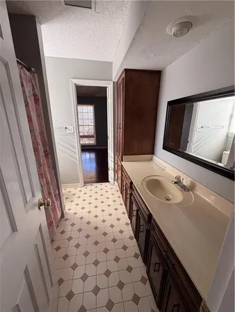 a bathroom with a sink a toilet a mirror and shower