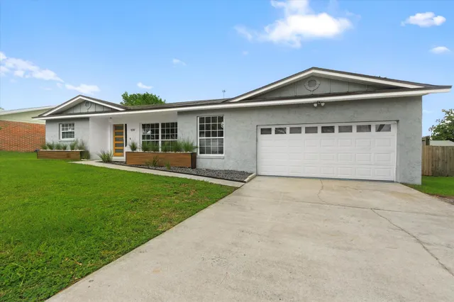 a front view of a house with a garden and yard