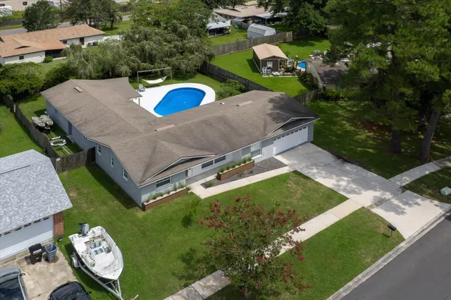 an aerial view of a house with a garden and lake view