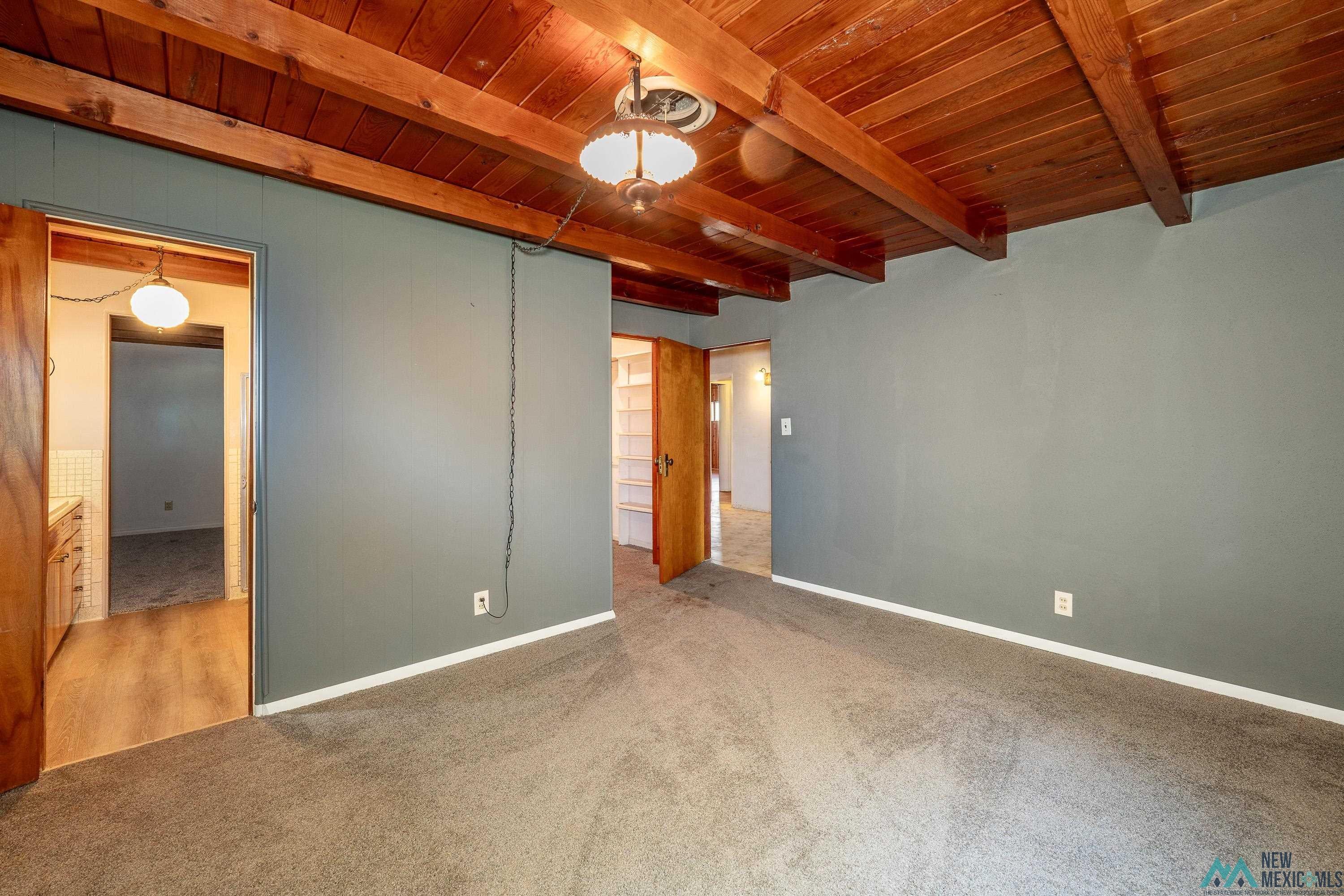 35234 Highway 87 Raton, NM 87740 - Photo 19 of 90 Unfurnished bedroom with carpet floors and a wooden ceiling with exposed beams