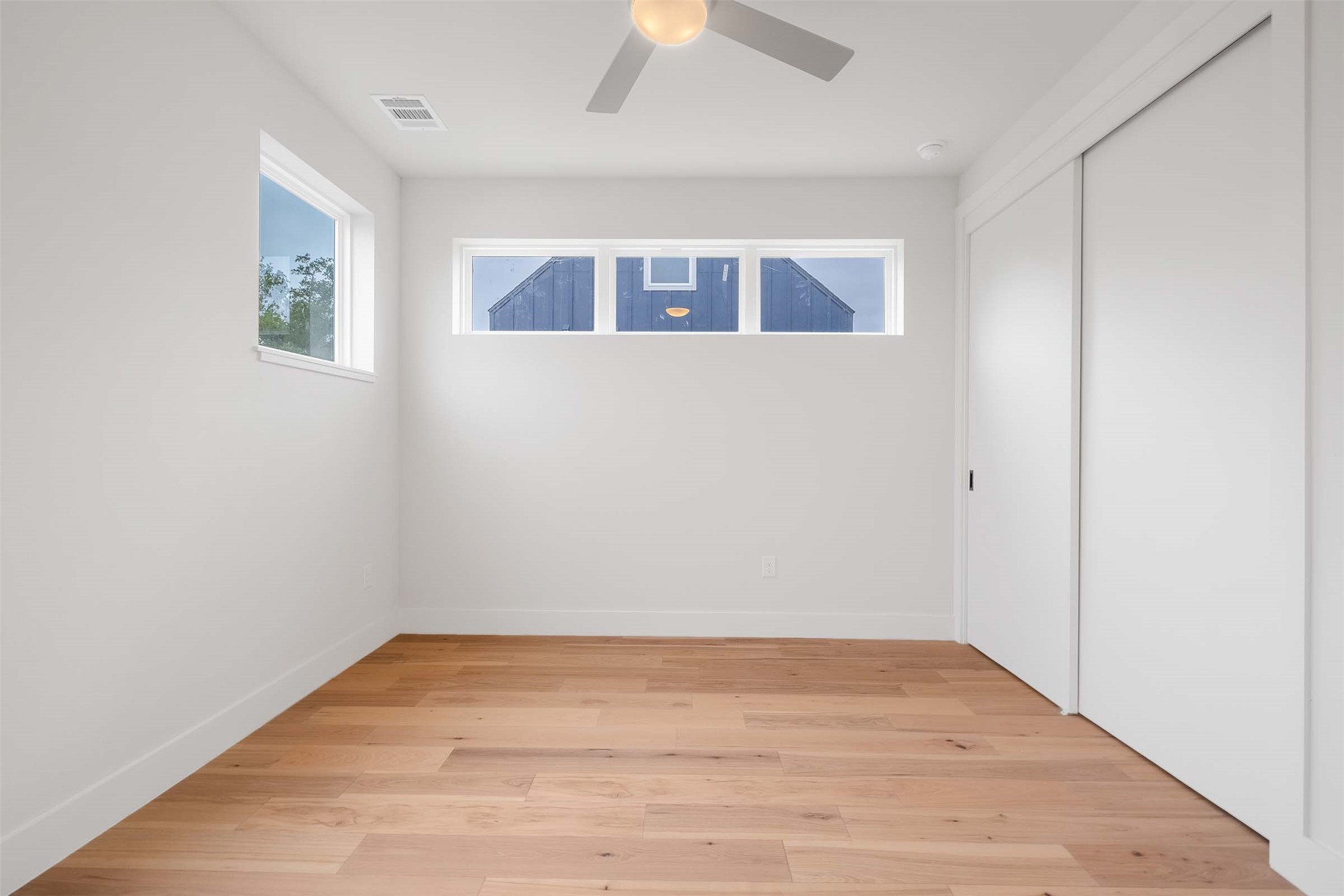 4513 South 3rd Street, Unit 2 Austin, TX 78745 - Photo 17 of 29 an empty room with wooden floor a ceiling fan and windows