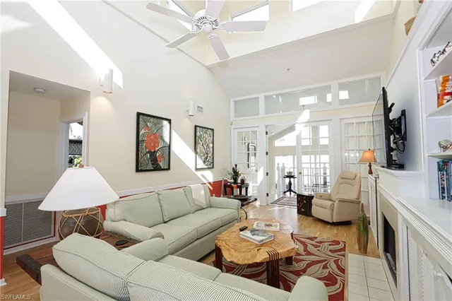 a living room with furniture a large window and a chandelier