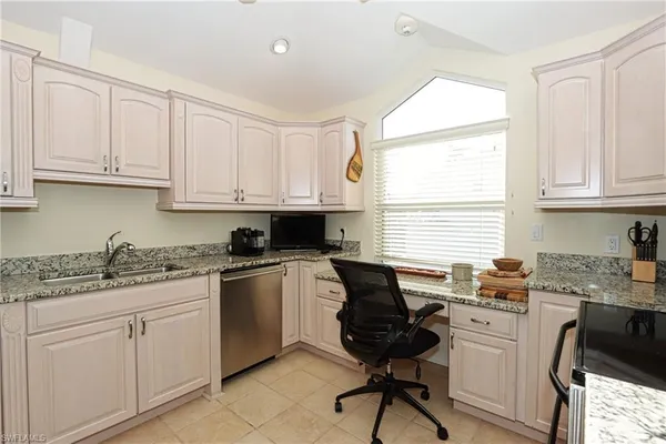 a kitchen with stainless steel appliances granite countertop white cabinets sink and a granite counter tops