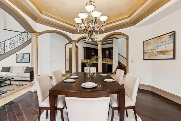 a view of a dining room with furniture a chandelier and wooden floor