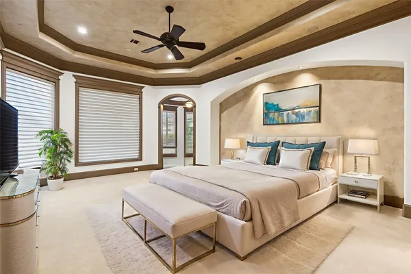 a spacious bedroom with a bed and a chandelier