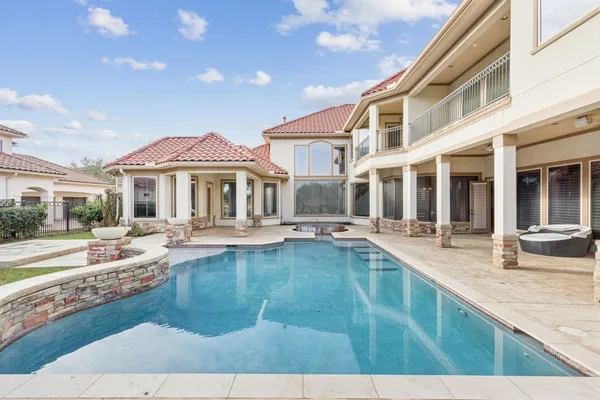a view of a house with swimming pool and sitting area