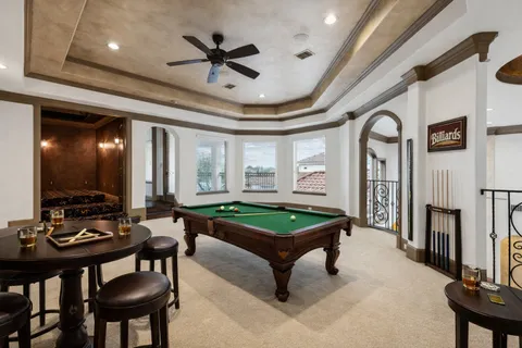 a spacious bedroom with a bed a couch and large window