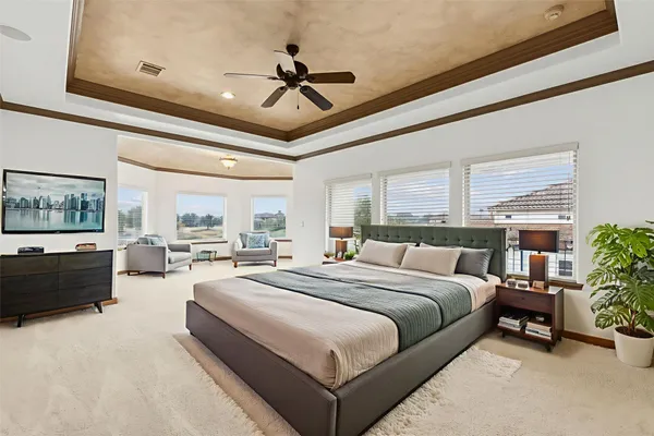a spacious bedroom with a bed a couch and large window