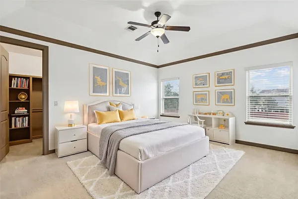 a spacious bedroom with a large bed a chandelier and windows