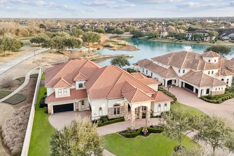an aerial view of residential houses with outdoor space and lake view