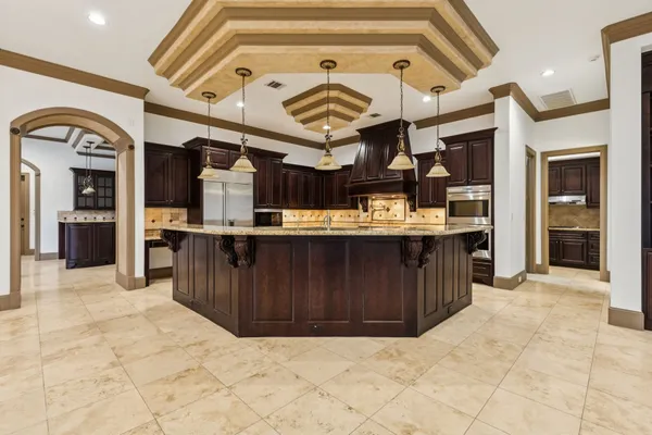 a view of kitchen with stainless steel appliances granite countertop a stove and cabinets