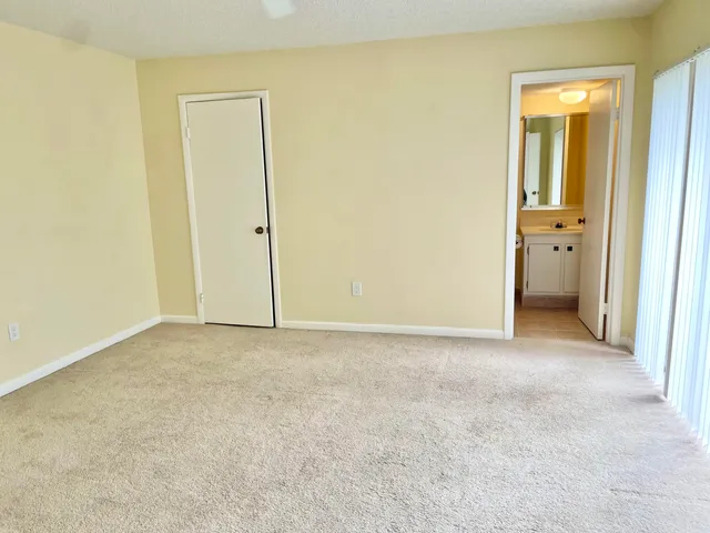 an empty room with windows and bathroom view