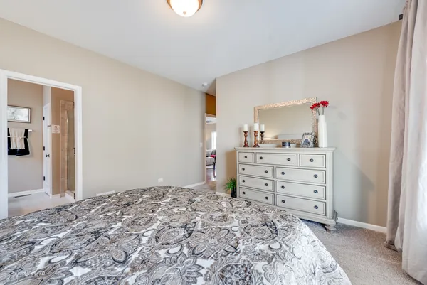 a bedroom with a dresser and a mirror