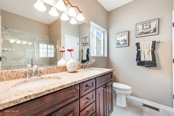 a bathroom with a granite countertop sink a toilet and a mirror