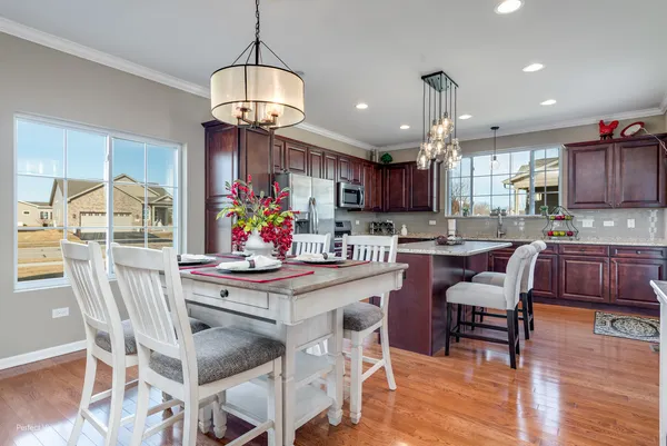 a view of a dining room with furniture a chandelier and wooden floor