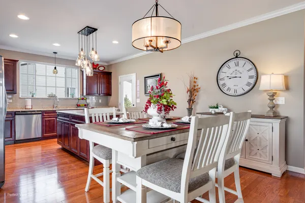 a dining room with wooden floor a glass table and chairs