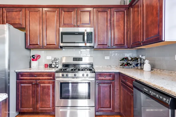 a kitchen with stainless steel appliances granite countertop a stove and a microwave
