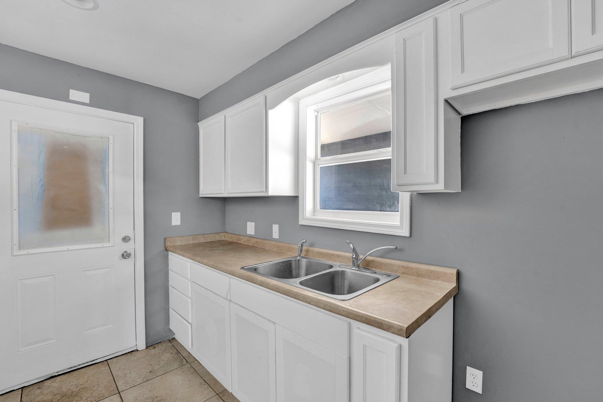 2161 Charjean Road Memphis, TN 38114 - Photo 6 of 18 Kitchen with sink, white cabinets, and light tile patterned floors