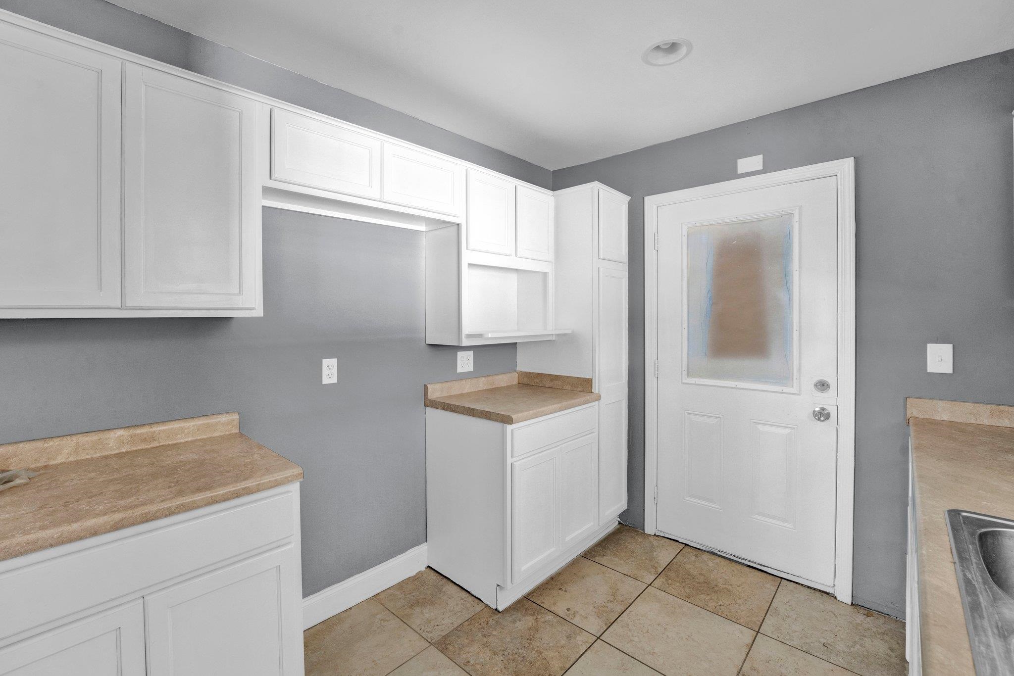 2161 Charjean Road Memphis, TN 38114 - Photo 7 of 18 Kitchen featuring sink, white cabinetry, and light tile patterned flooring