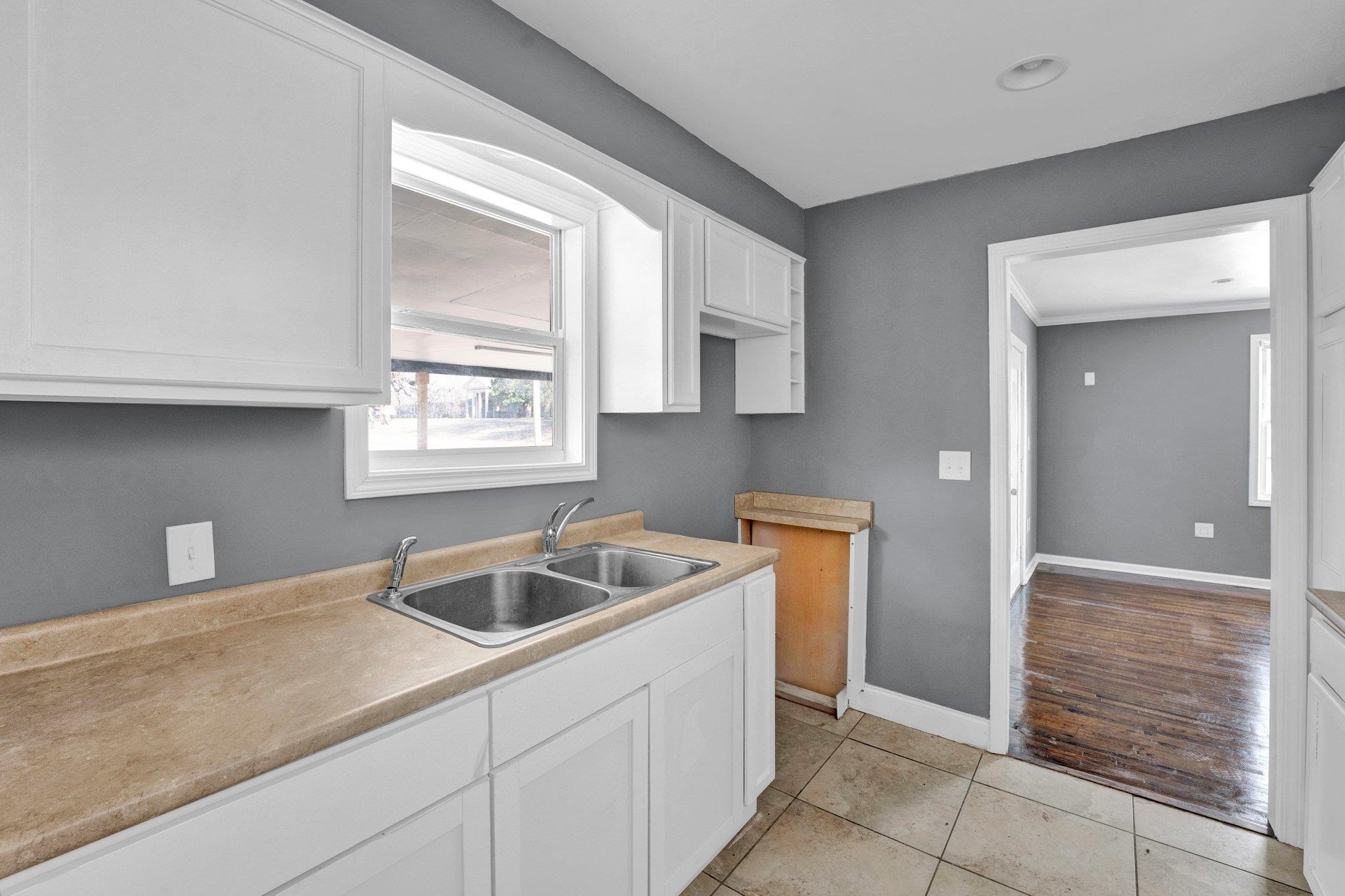 2161 Charjean Road Memphis, TN 38114 - Photo 8 of 18 Kitchen featuring light tile patterned floors, white cabinetry, and sink