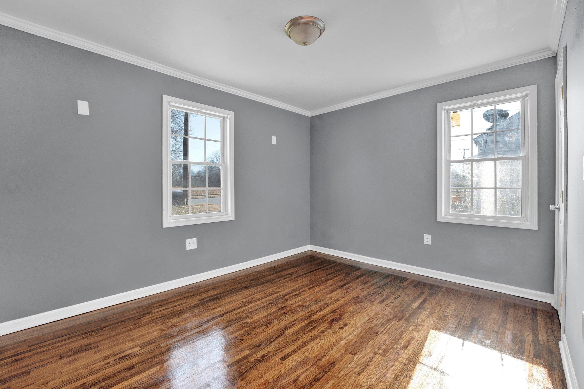 2161 Charjean Road Memphis, TN 38114 - Photo 9 of 18 Spare room featuring crown molding, a healthy amount of sunlight, and dark hardwood / wood-style floors
